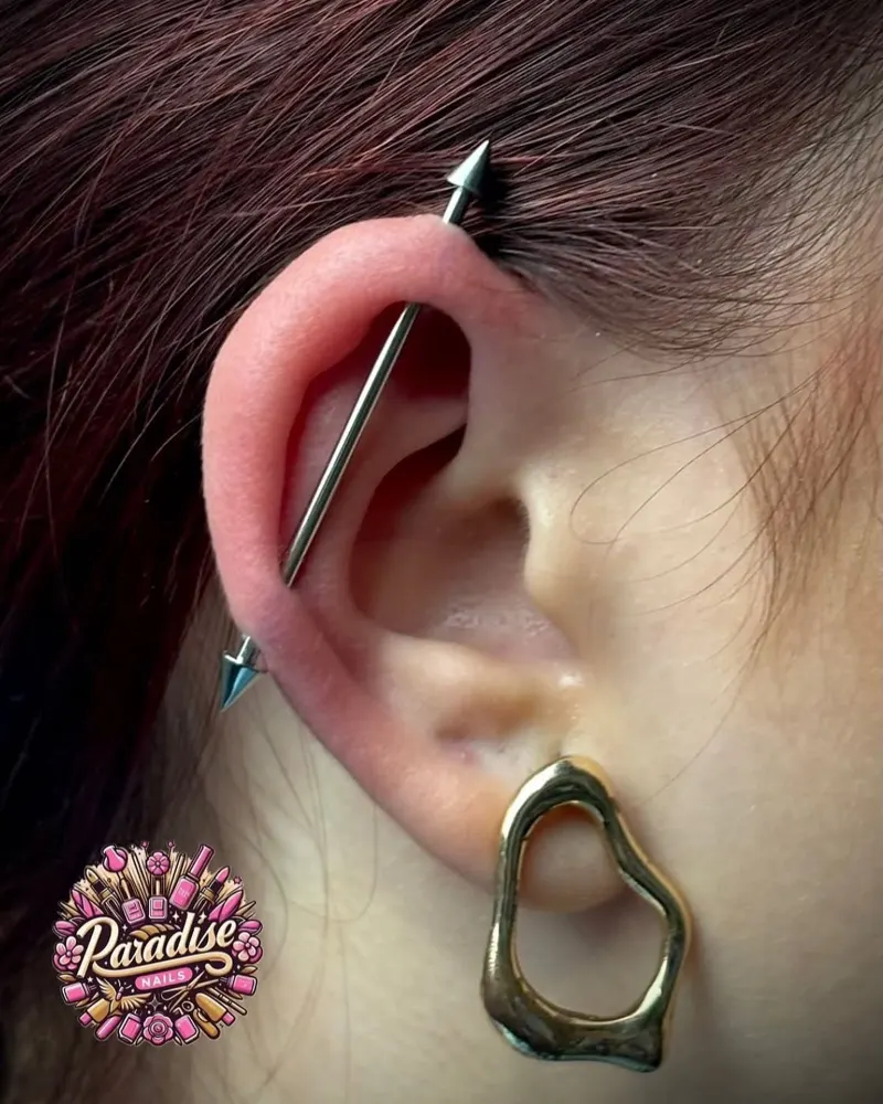Piercing industrial con barra en la oreja