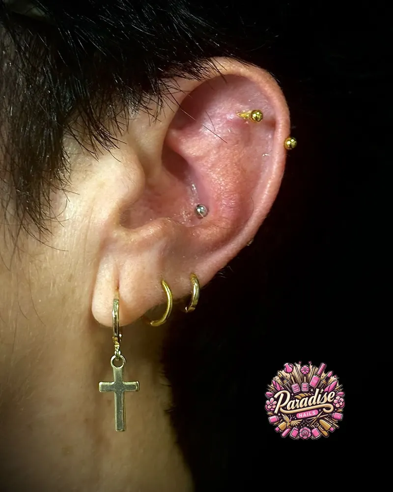 Piercings de hélix y lóbulo con aros dorados