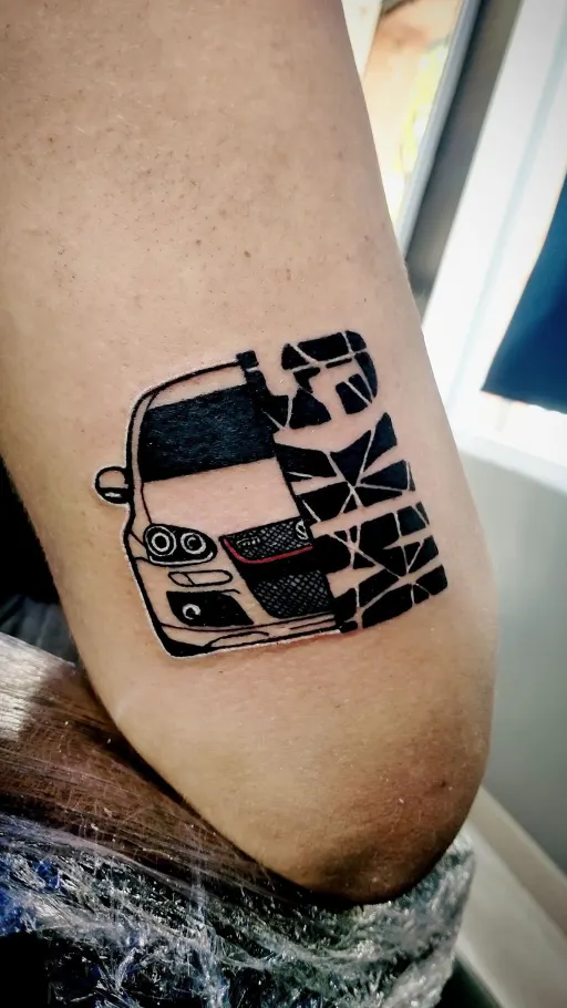 Tatuaje blackwork de un coche en el brazo