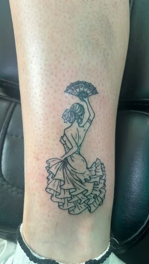 Tatuaje fine line de una bailaora flamenca con abanico en la pierna, hecho en Sevilla